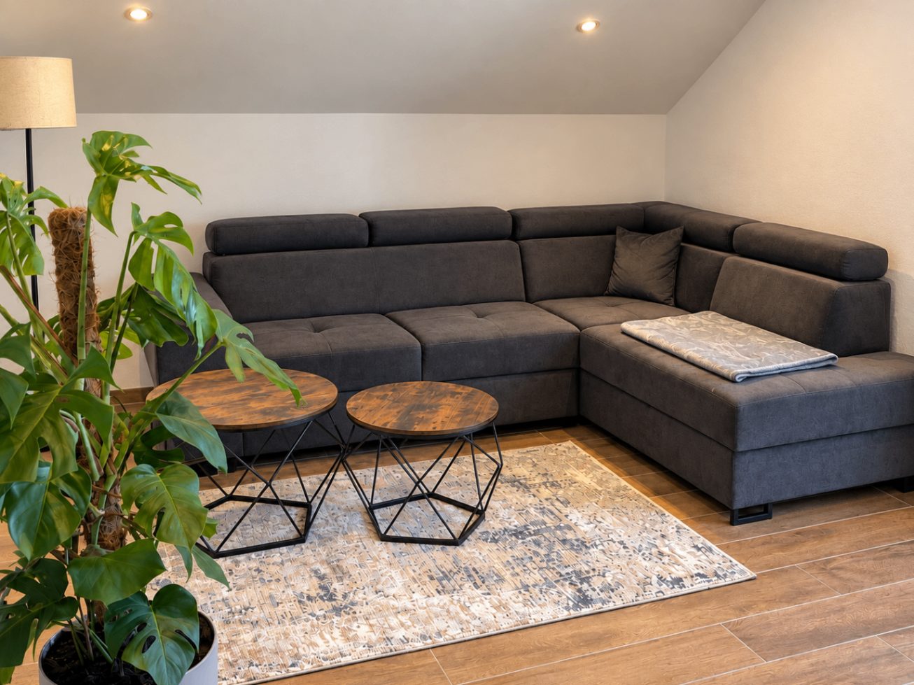 Wohnbereich der Ferienwohnung Karl in Lalling mit großer Eckcouch und Holzboden